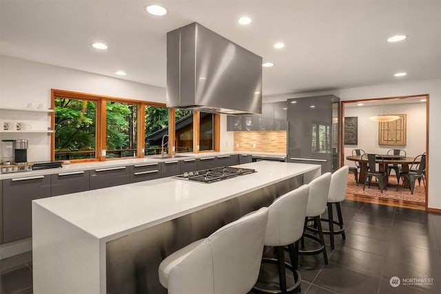 kitchen featuring sink, gray cabinetry, a center island, island exhaust hood, and stainless steel gas stovetop