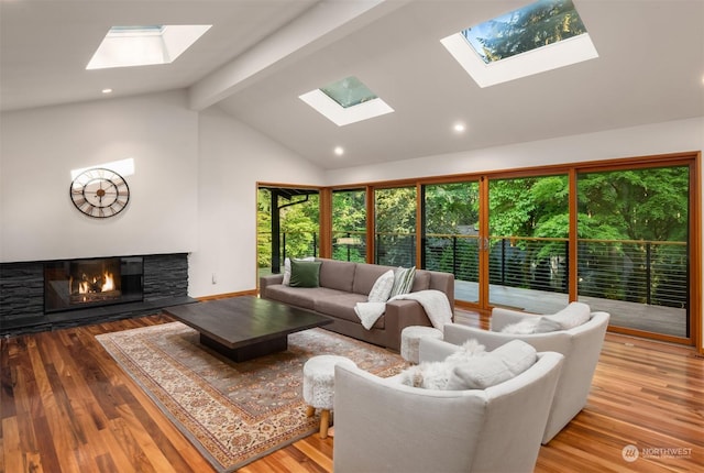living room with light hardwood / wood-style flooring, a fireplace, high vaulted ceiling, and beamed ceiling