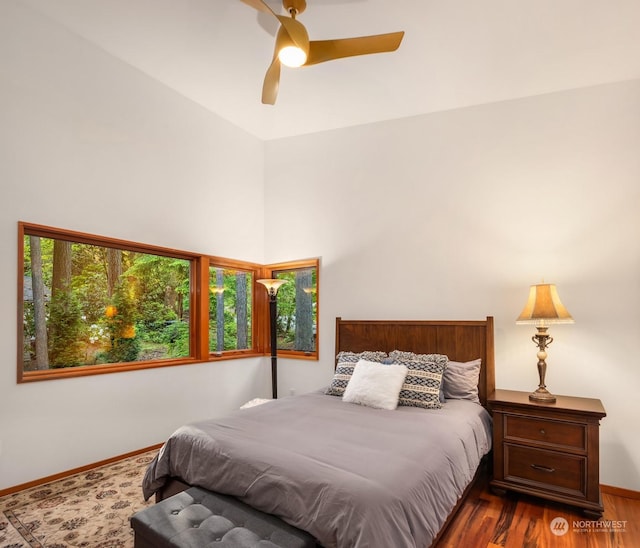 bedroom with multiple windows, dark hardwood / wood-style floors, and ceiling fan
