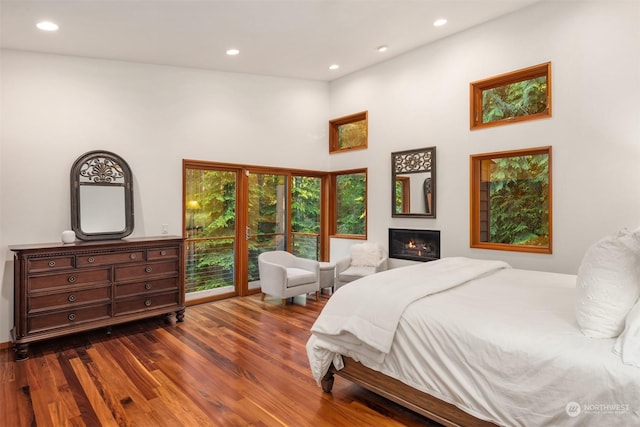 bedroom featuring a high ceiling and dark hardwood / wood-style flooring