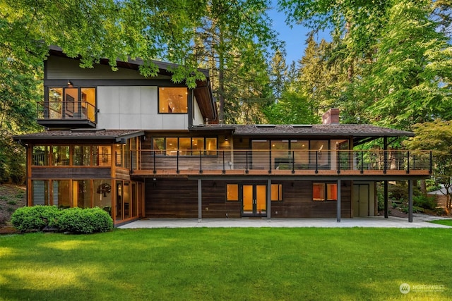 rear view of property with a patio, a wooden deck, and a lawn
