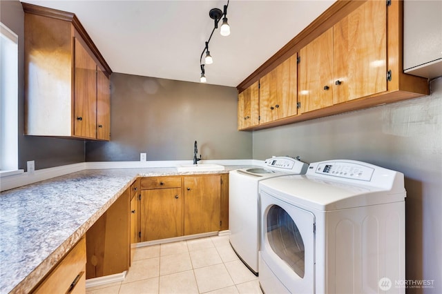 washroom with washer and dryer, sink, light tile patterned floors, and cabinets