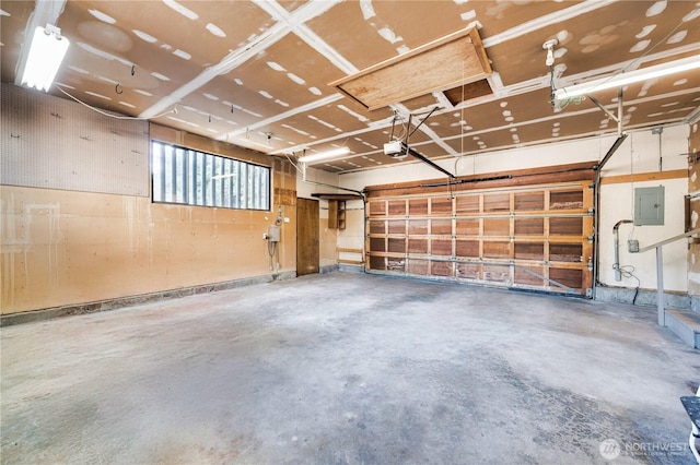 garage with a garage door opener and electric panel