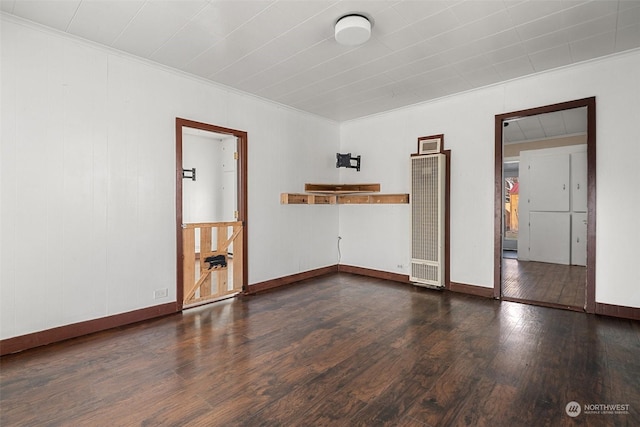 empty room featuring baseboards, dark wood finished floors, and crown molding