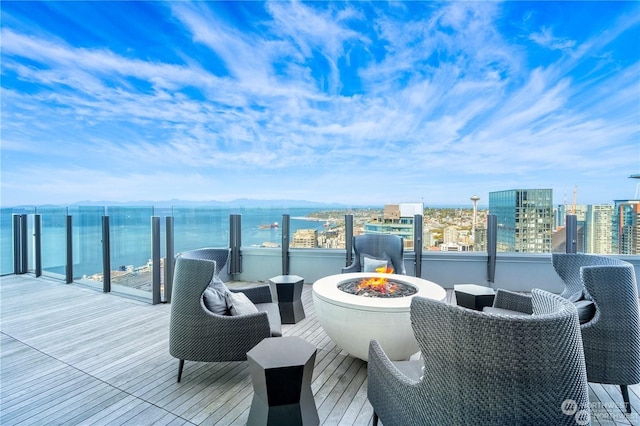 balcony with a water view and a fire pit