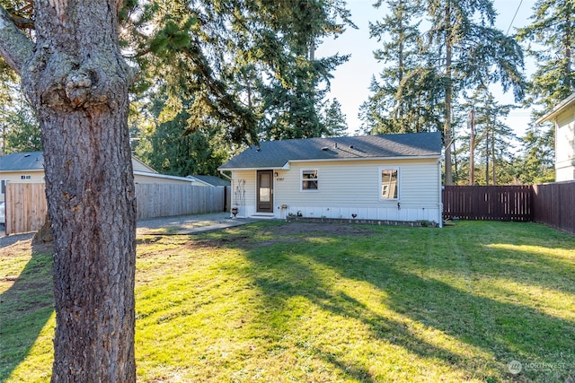 view of front facade with a fenced backyard and a front lawn