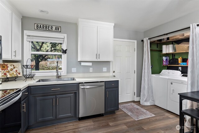 kitchen with white cabinets, dark wood-type flooring, independent washer and dryer, stainless steel dishwasher, and a sink