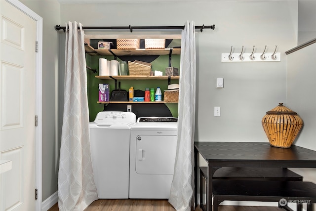 clothes washing area with wood finished floors, laundry area, and separate washer and dryer