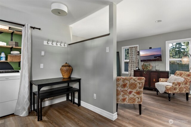 sitting room with baseboards, washer / clothes dryer, and wood finished floors