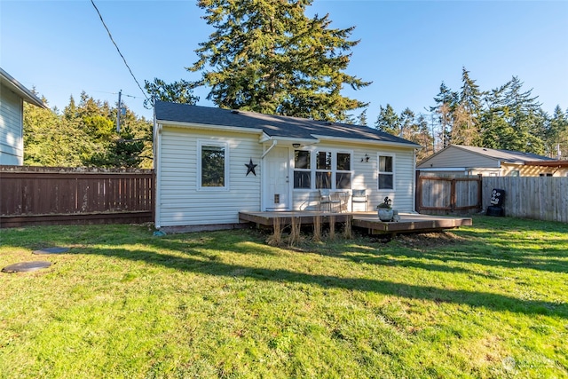 back of property with a fenced backyard, a lawn, and a deck