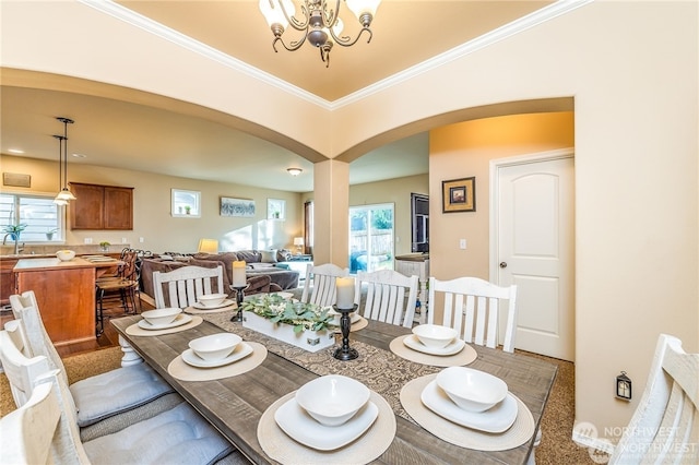 dining space featuring an inviting chandelier, plenty of natural light, and ornamental molding