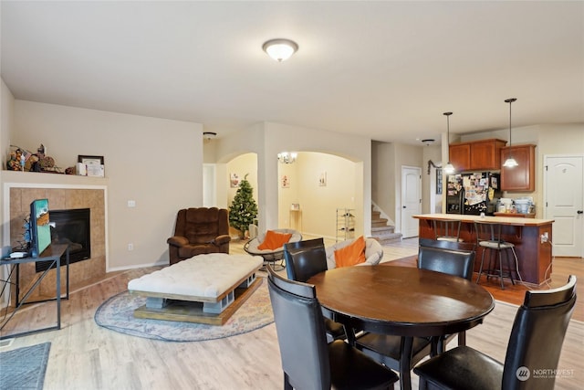 dining area featuring light wood-type flooring and a fireplace