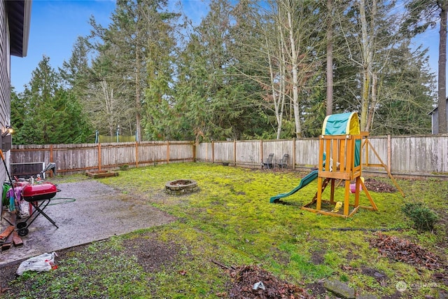 view of yard featuring a playground and a fire pit