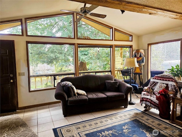 living area featuring a wealth of natural light, vaulted ceiling with beams, baseboards, and light tile patterned floors