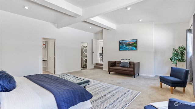 carpeted bedroom with stacked washer / dryer and vaulted ceiling with beams