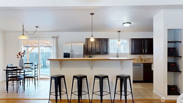 27223 154th Ave SE, Kent, WA 98042 - kitchen with stainless steel appliances, a kitchen breakfast bar, light countertops, and plenty of natural light