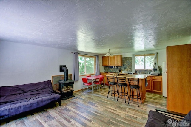 interior space with white refrigerator, a center island, a kitchen bar, and light wood-type flooring