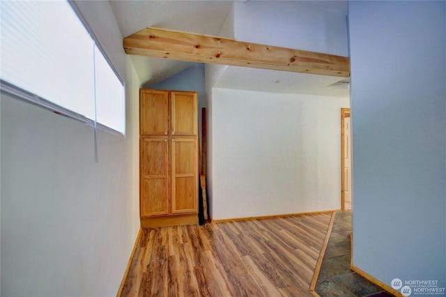 corridor with hardwood / wood-style flooring and lofted ceiling