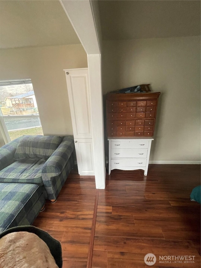 living area with dark wood-style flooring and baseboards