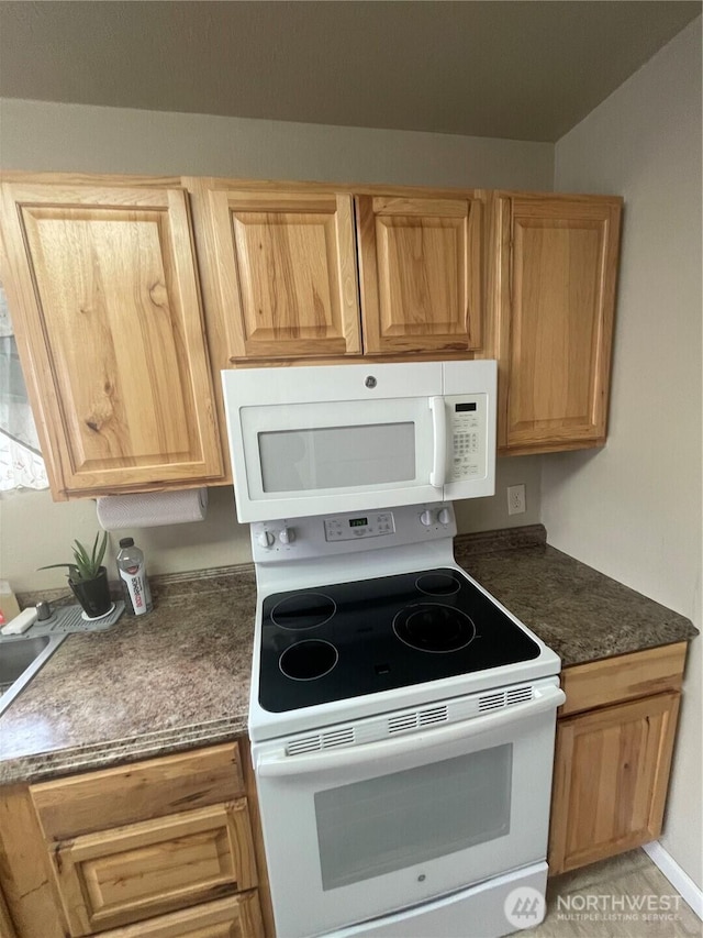 kitchen featuring white appliances and dark countertops