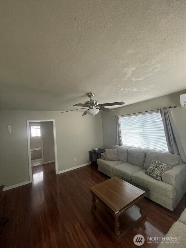 living area featuring dark wood-style floors, ceiling fan, a wealth of natural light, and baseboards