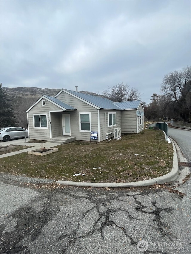 view of front of home with metal roof and a front yard