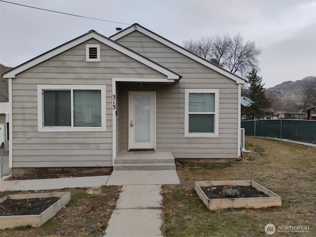 bungalow-style house with fence and a garden