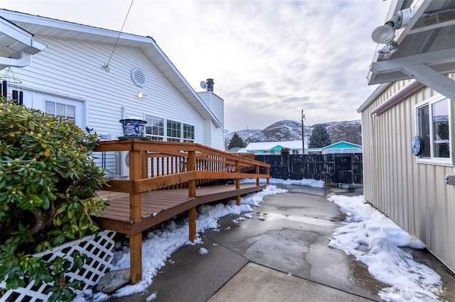 wooden terrace with fence, a patio, and a mountain view