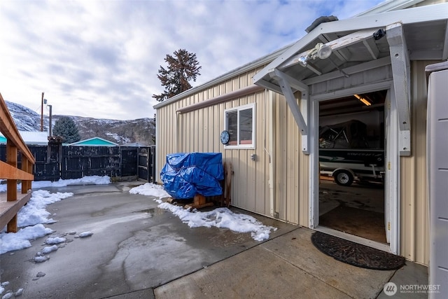 snow covered patio with fence and a mountain view