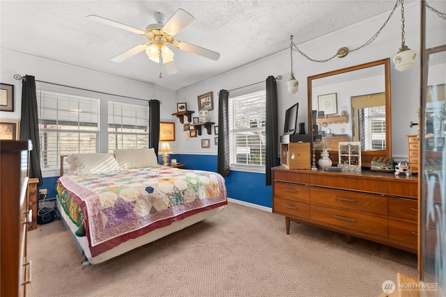 bedroom featuring a textured ceiling, light carpet, a ceiling fan, and baseboards