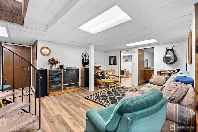 living room featuring a paneled ceiling and light wood finished floors