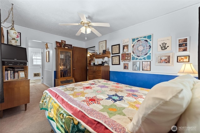 carpeted bedroom with a ceiling fan and a textured ceiling