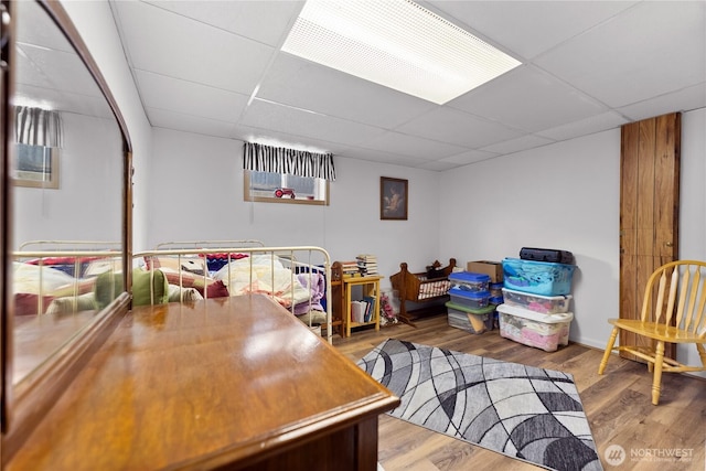 rec room featuring a drop ceiling and wood finished floors