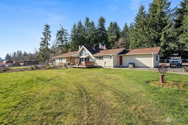 ranch-style house featuring a front yard, central air condition unit, and a deck