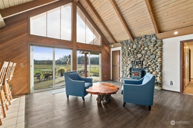 living area featuring beamed ceiling, wood-type flooring, wooden ceiling, and wooden walls