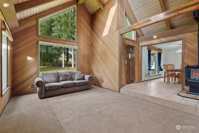 carpeted living room with beamed ceiling, wood ceiling, a chandelier, and wood walls