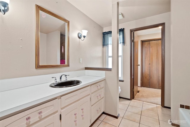 bathroom with tile patterned flooring, vanity, a healthy amount of sunlight, and toilet