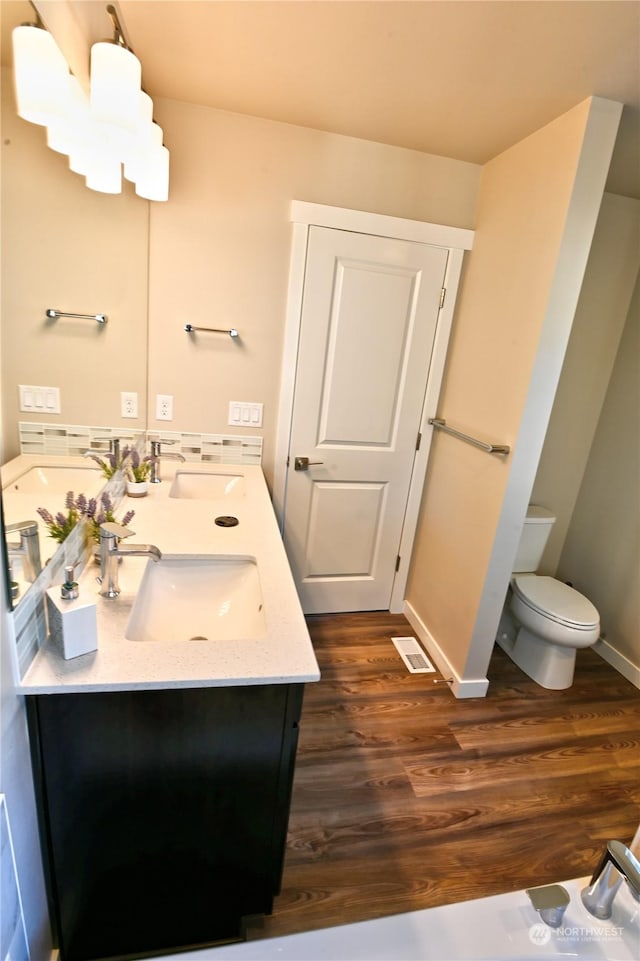 bathroom with hardwood / wood-style flooring, vanity, and toilet