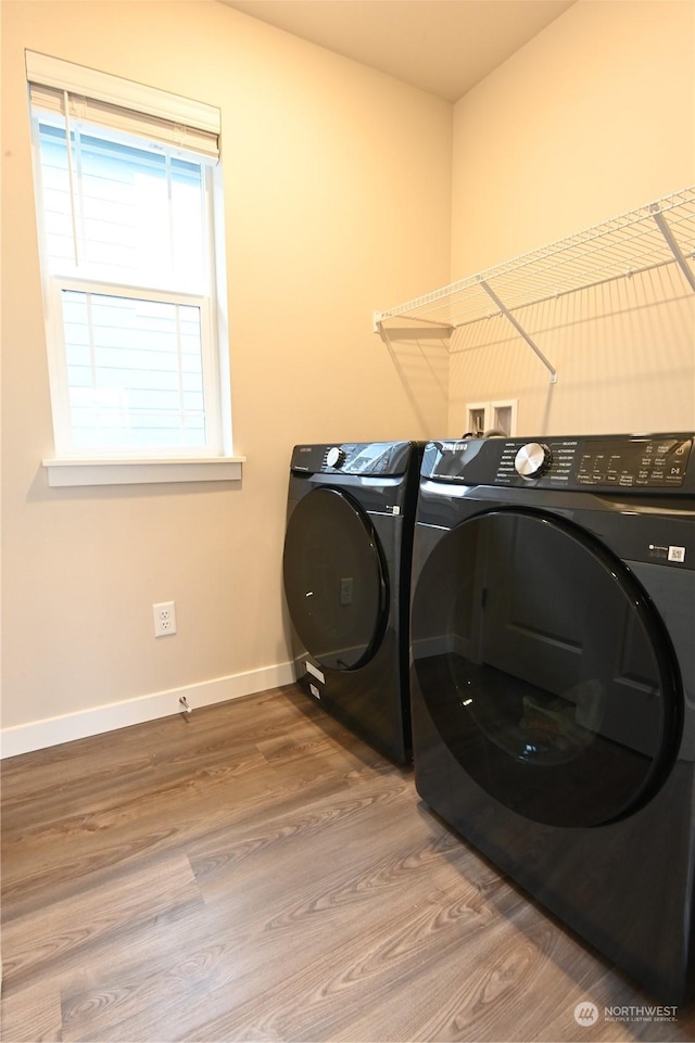 laundry area with hardwood / wood-style floors and washer and dryer