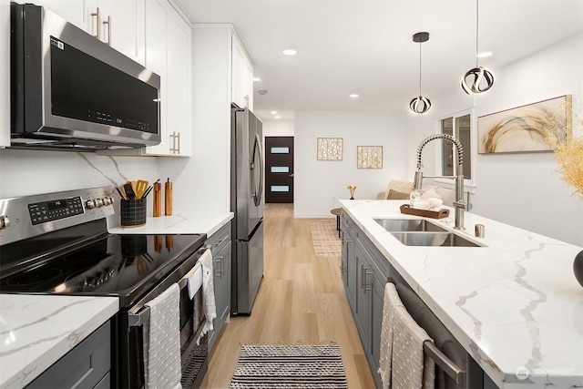 kitchen featuring sink, decorative light fixtures, stainless steel appliances, and white cabinets