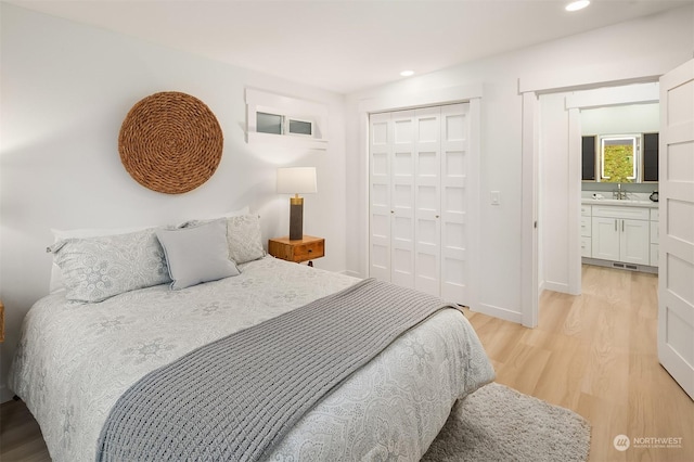 bedroom with sink, a closet, and light wood-type flooring