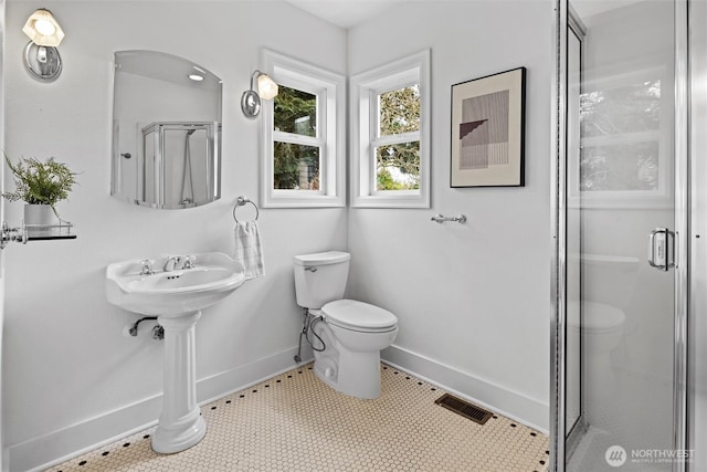 full bath featuring toilet, visible vents, a stall shower, and baseboards