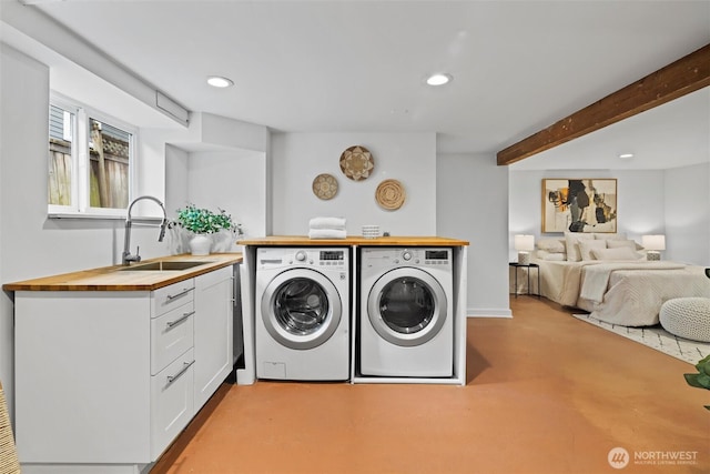 clothes washing area featuring a sink, separate washer and dryer, and recessed lighting