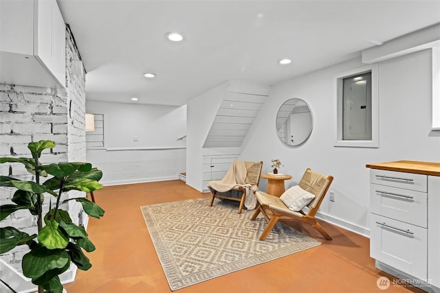 living area featuring electric panel, recessed lighting, and concrete floors