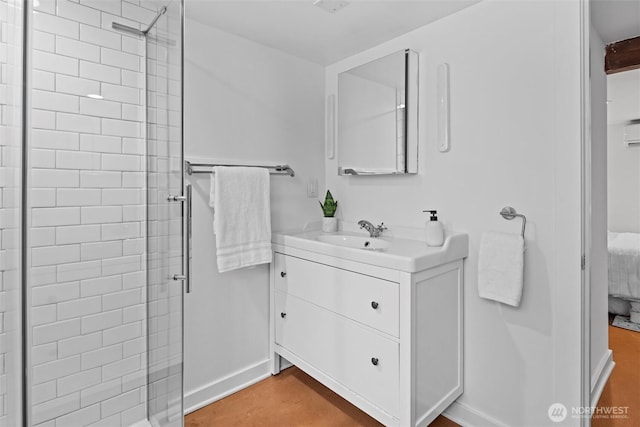 bathroom featuring baseboards, ensuite bath, a stall shower, and vanity