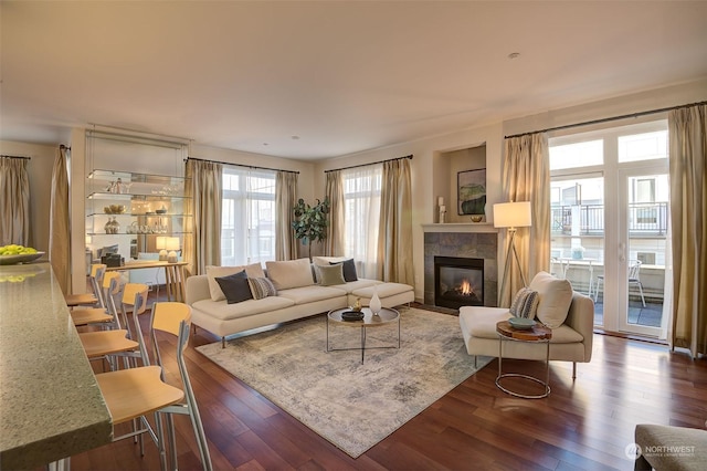 living room featuring a tile fireplace and dark hardwood / wood-style floors