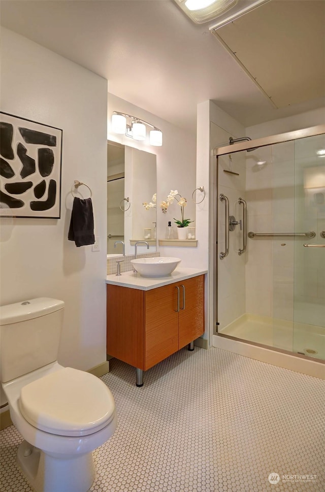 bathroom featuring vanity, a shower with shower door, tile patterned floors, and toilet