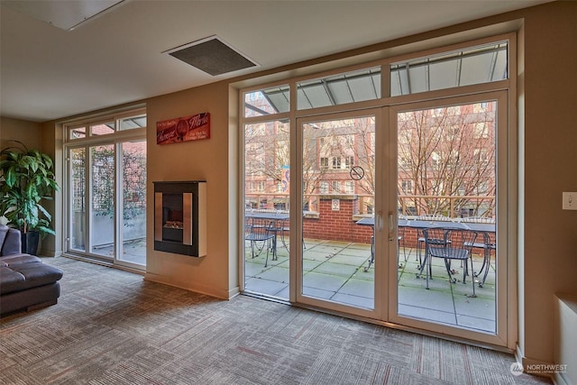 doorway to outside with a healthy amount of sunlight and carpet