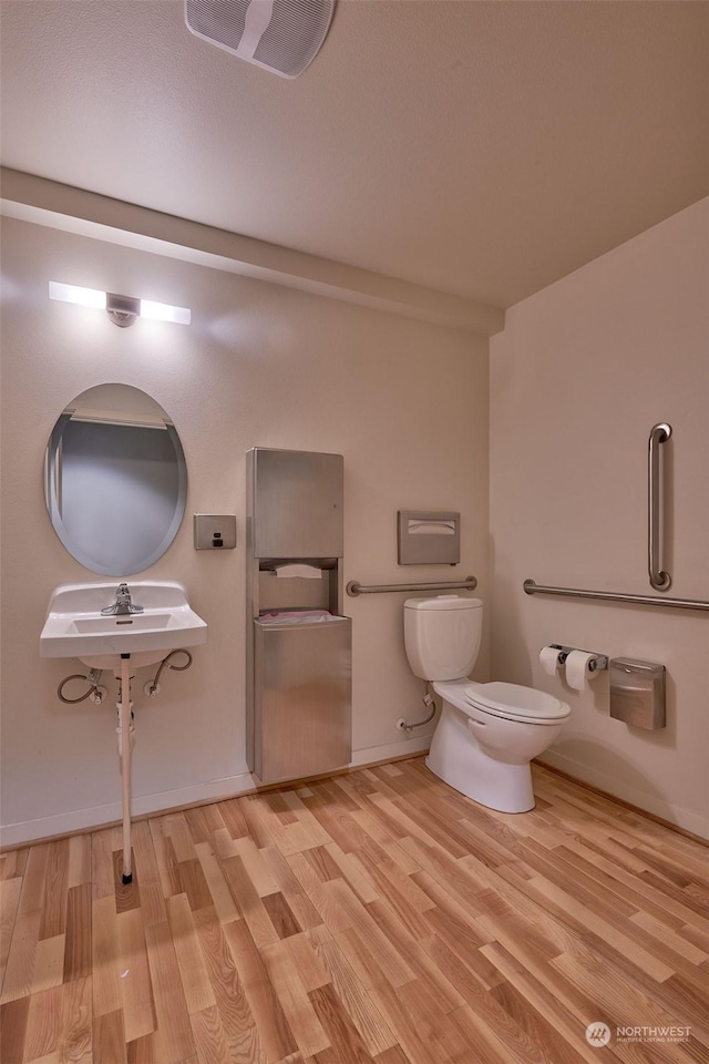 bathroom featuring wood-type flooring and toilet