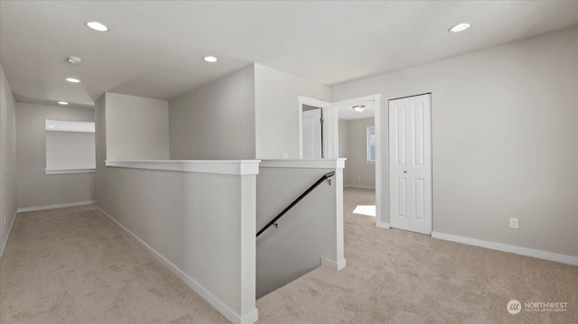 hallway featuring light colored carpet